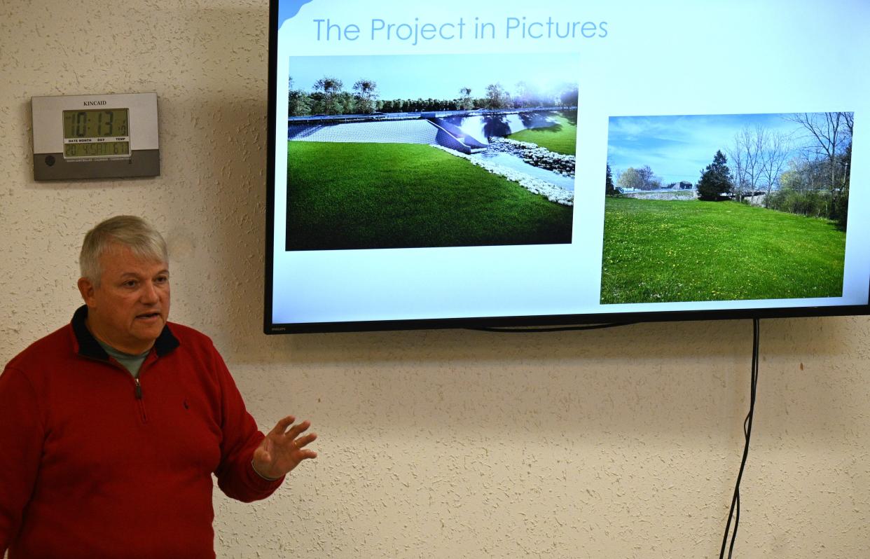 Lake George Conservancy Chair John Ranshaw shows design drawings of dam improvements at the Saturday public hearing.