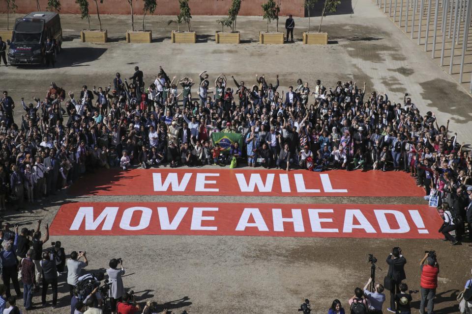 FILE - Participants at the COP22 climate conference pose in support of climate negotiations and Paris agreement, on the last day of the conference, in Marrakech, Morocco, Nov. 18, 2016. The U.N. climate summit is back in Africa after six years and four consecutive Europe-based conferences. Marrakech is the last African city to host the event, that aimed to implement some of the Paris goals. (AP Photo/David Keyton, File)
