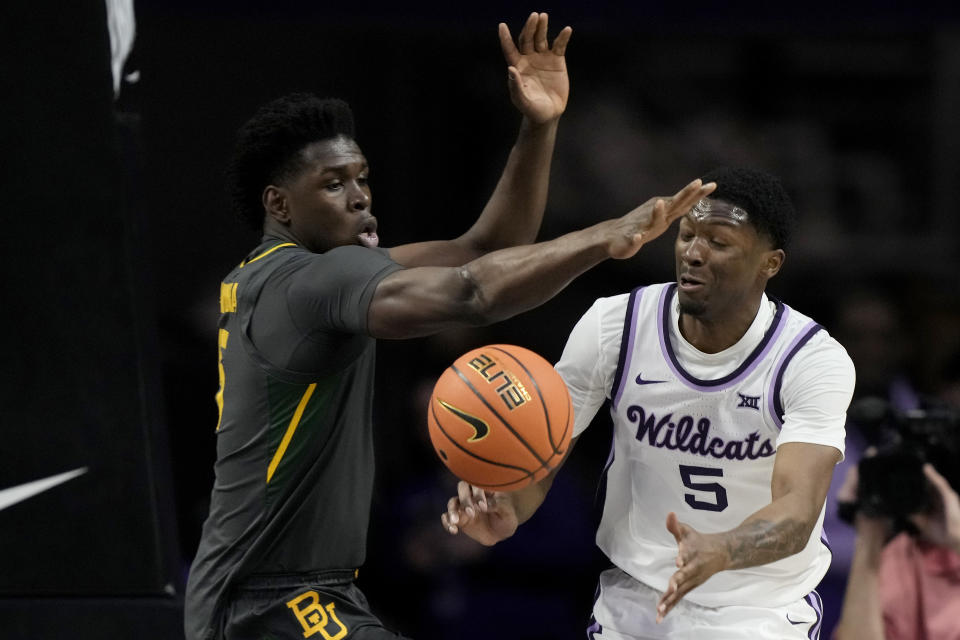 Kansas State guard Cam Carter (5) passes around Baylor forward Josh Ojianwuna during the first half of an NCAA college basketball game Tuesday, Jan. 16, 2024, in Manhattan, Kan. (AP Photo/Charlie Riedel)