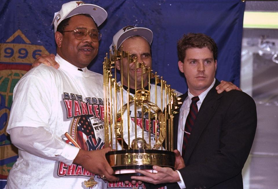 General manger Bob Watson and manager Joe Torre of the New York Yankees hold trophy after winning game six of the World Series against the Atlanta Braves at Yankee Stadium in 1996. (Getty Images)
