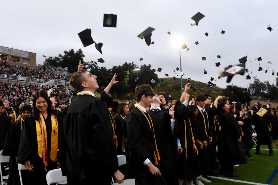 Ray McIver Beindorf looks up as caps fill the air as the Oak Park High Class of 2024 celebrates during its commencement on Thursday. More than 350 high school graduates earned diplomas in the evening ceremony.