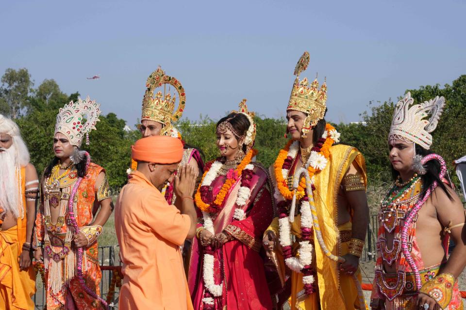 Uttar Pradesh state Chief Minister Yogi Adityanath greets artists dressed as Hindu god Ram, goddess Sita and Lakshman on the banks of river Saryu on the eve of Diwali, the Hindu festival of lights, in Ayodhya, India. Sunday, Oct. 23, 2022. (AP Photo/Rajesh Kumar Singh)