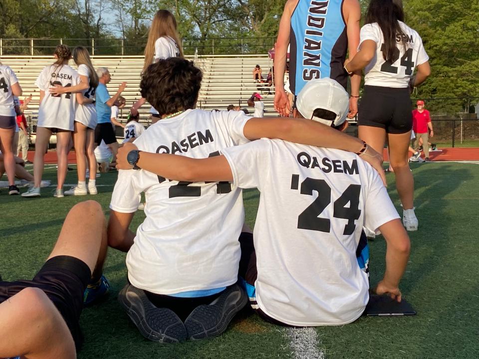 Members of the Saint Joe boys track team console each other during ceremony for Saleem Qasem. [JUSTIN FROMMER/THE SOUTH BEND TRIBUNE]