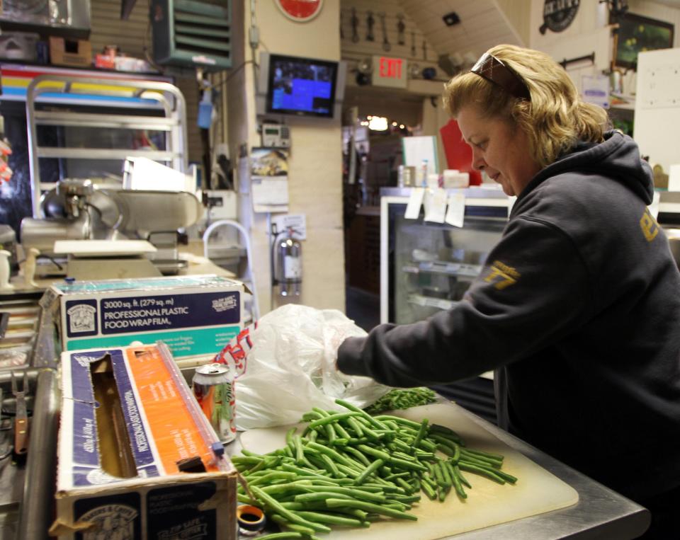  <p> In this photo taken Thursday Dec. 6, 2012, owner of Robie's Country Store and Deli Debbie Chouinard works on cutting up green beans. (AP Photo/Jim Cole) </p>