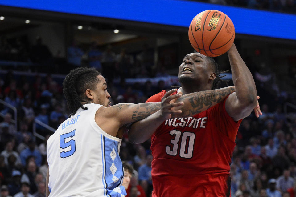 North Carolina State forward DJ Burns Jr. (30) is fouled by North Carolina forward Armando Bacot (5) during the second half of an NCAA college basketball game in the championship of the Atlantic Coast Conference tournament, Saturday, March 16, 2024, in Washington. (AP Photo/Nick Wass)