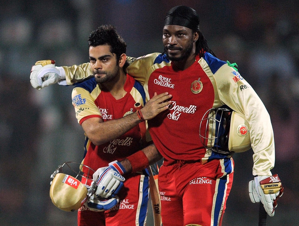 Royal Challengers Bangalore batsman Chris Gayle (R) hugs teammate Virat Kohli after the end of their innings during the IPL Twenty20 cricket match between Delhi Daredevils and Royal Challengers Bangalore at the Feroz Shah Kotla stadium in New Delhi on May 17, 2012.      RESTRICTED TO EDITORIAL USE. MOBILE USE WITHIN NEWS PACKAGE. AFP PHOTO/ MANAN VATSYAYANA          (Photo credit should read MANAN VATSYAYANA/AFP/GettyImages)