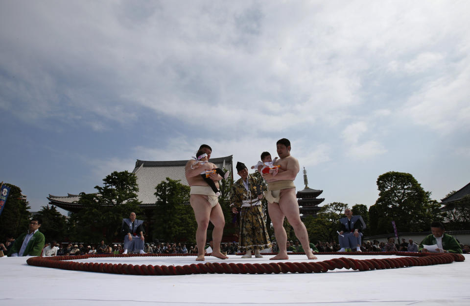 An unidentified baby, held by a college sumo wrester, cries during Naki Sumo, or Crying Baby Contest, as a judge looks on at Sensoji temple in Tokyo Monday, April 29, 2013. The babies born in 2012 participated in the annual traditional ritual performed as a prayer for their healthy growth.