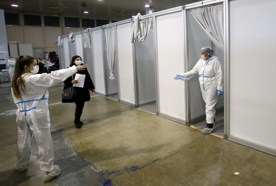 People arrive to receive a dose of Chinese Sinopharm COVID-19 vaccine during the vaccination at Belgrade Fair makeshift vaccination center in Belgrade, Serbia, Wednesday, Feb. 17, 2021. Serbian health expert Chief epidemiologist Predrag Kon on Tuesday March 2, 2021, called for the government to introduce a state of emergency and a strict lockdown to halt a surge in coronavirus infections in the Balkan country. (AP Photo/Darko Vojinovic)