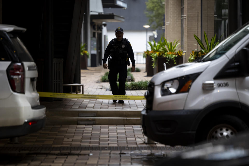 FILE - A law enforcement officer walks outside of 1201 San Jacinto in Houston, following a shooting on Nov. 1, 2022. Authorities said Wednesday, Nov. 30, that a man who has been accused of illegally having a gun at the time that rapper Takeoff was fatally shot last month outside a private party at a downtown Houston bowling alley has been charged in connection with the case. (Annie Mulligan/Houston Chronicle via AP, File)