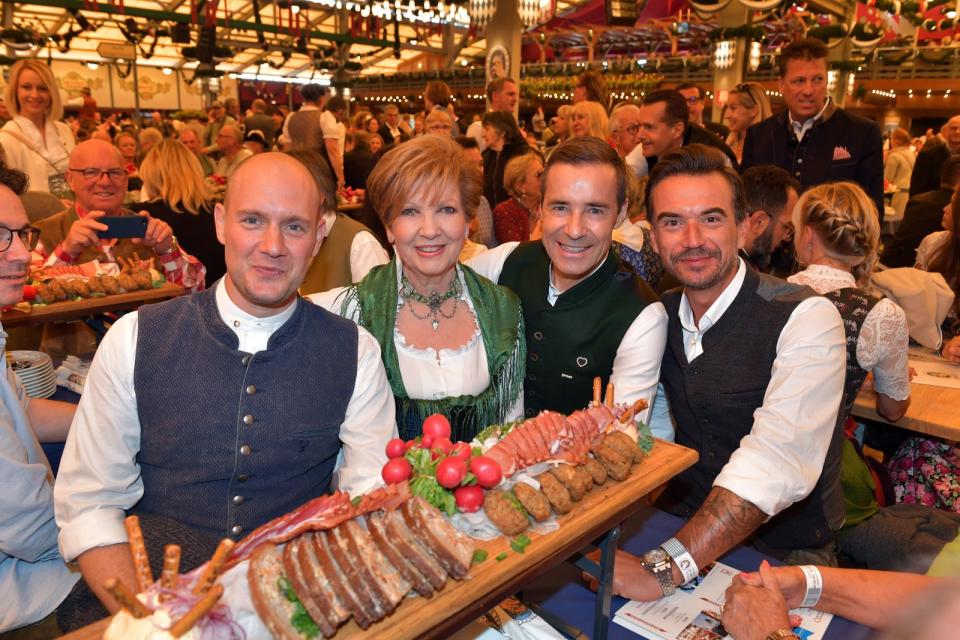 <p>Und auch 2019 feierte Silbereisen (rechts) die Eröffnung des Oktoberfestes mit Brotzeitbrettl und prominenten Gästen: (von links): Oliver Petszokat, Carolin Reiber und Kai Pflaume. (Bild: Hannes Magerstaedt/Getty Images)</p>