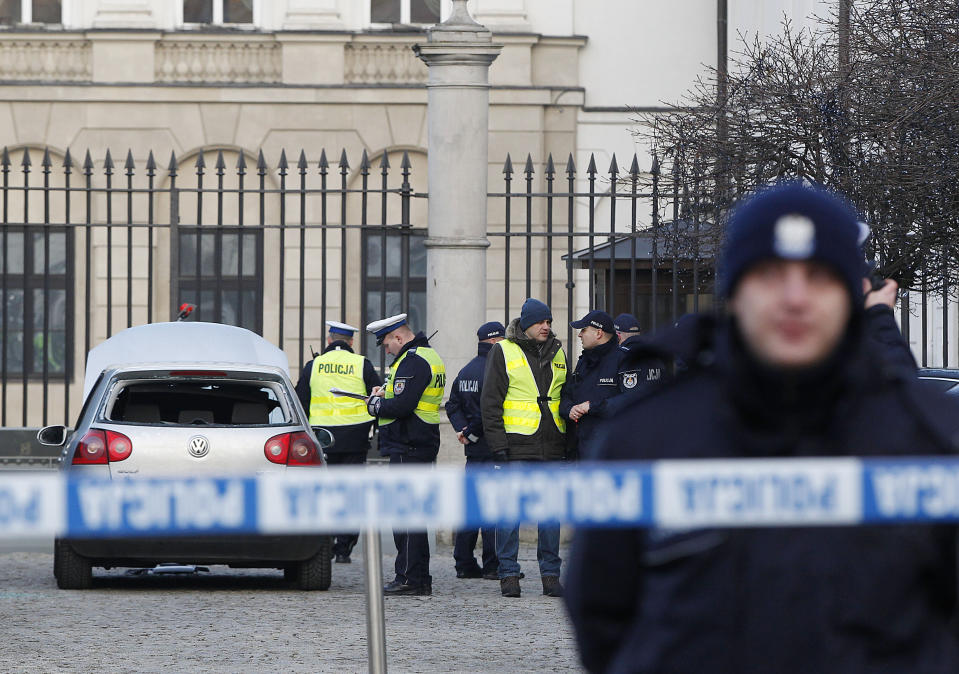 Police officers examine a car in the driveway to the Presidential Palace in Warsaw, Poland, Tuesday, Jan. 22, 2019 after a man rammed the car into a metal barrier protecting the driveway. The man was driving the wrong way and hit a policeman who was trying to stop him before ramming into the barrier. (AP Photo/Czarek Sokolowski)