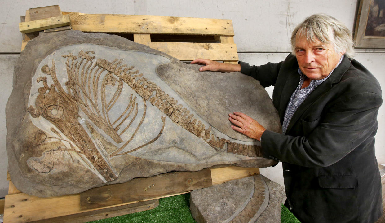 Cider brandy maker Julian Temperley next to the 90-million-year-old ichthyosaurus fossil (SWNS)