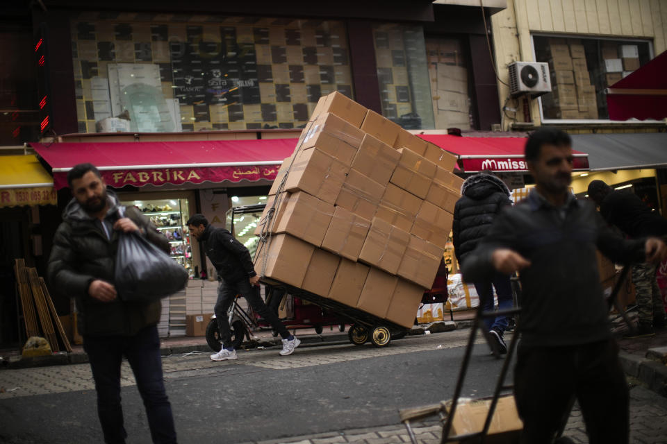 FILE - People carry goods in a commercial area in Istanbul, Turkey, Friday, Jan. 13, 2023. Recep Tayyip Erdogan, 69, takes the oath of office Saturday and starts his third presidential term after scoring another electoral victory last month. Already the longest-serving leader in the republic's history, Erdogan will now be stretching his rule into a third decade - until 2028 – and possibly even longer with the help of a friendly parliament. (AP Photo/Francisco Seco, file)