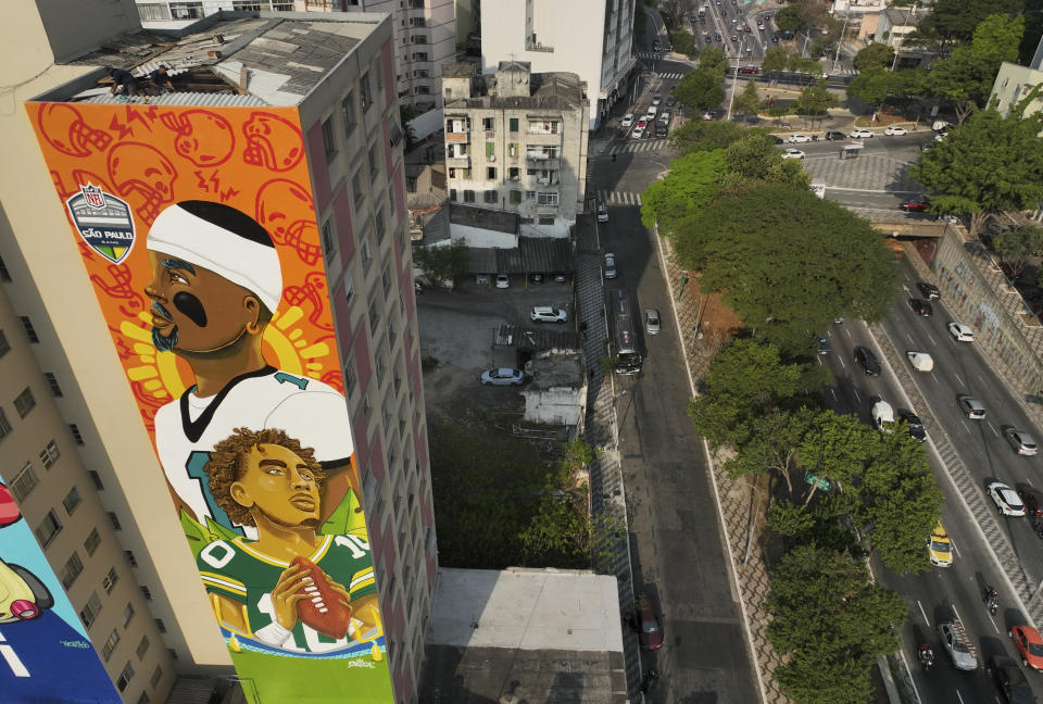 A mural by artist Crica featuring Philadelphia Eagles quarterback Jalen Hurts and Green Bay Packers quarterback Jordan Love adorns an apartment building in downtown Sao Paulo. (AP Photo/Andre Penner)