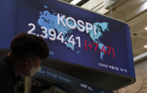 A man wearing a face mask stands near a screen showing the Korea Composite Stock Price Index (KOSPI) at the Korea Exchange in Seoul, South Korea, Thursday, Oct. 8, 2020. Asian shares were mostly higher Thursday on optimism that U.S. stimulus may be coming, as President Donald Trump appeared to reverse his earlier decision to halt talks on another economic rescue effort. (AP Photo/Lee Jin-man)