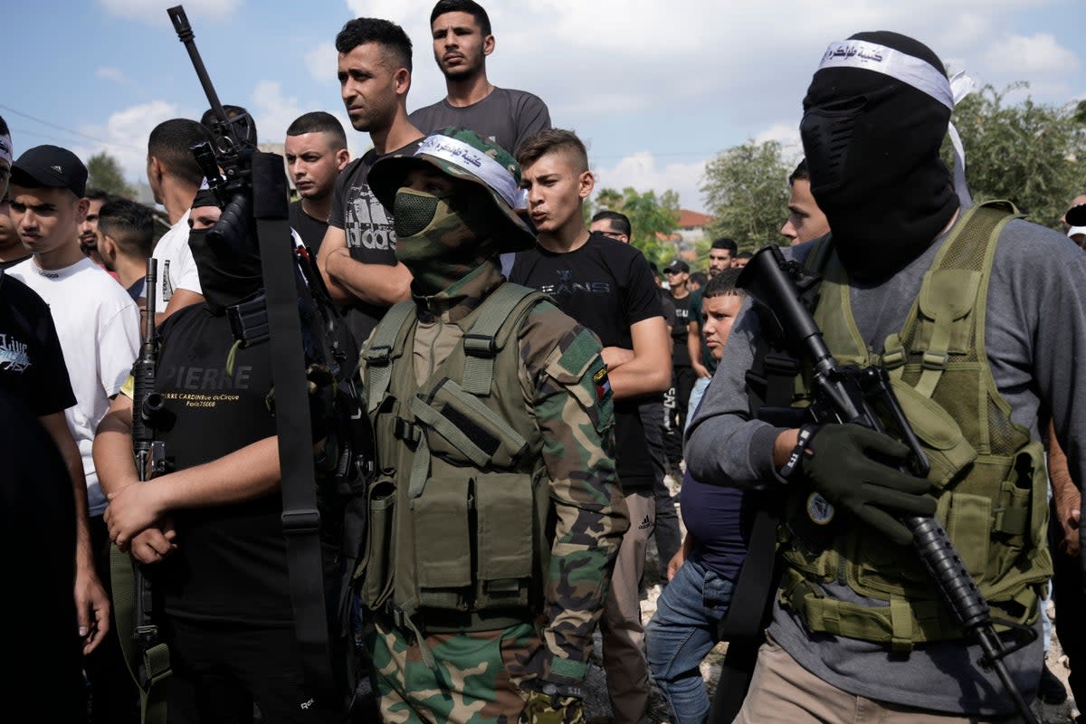 Palestinian militants attend a funeral on Friday of people killed during an Israeli military raid on a Palestinian refugee camp, Nur Shams, in the West Bank (AP)