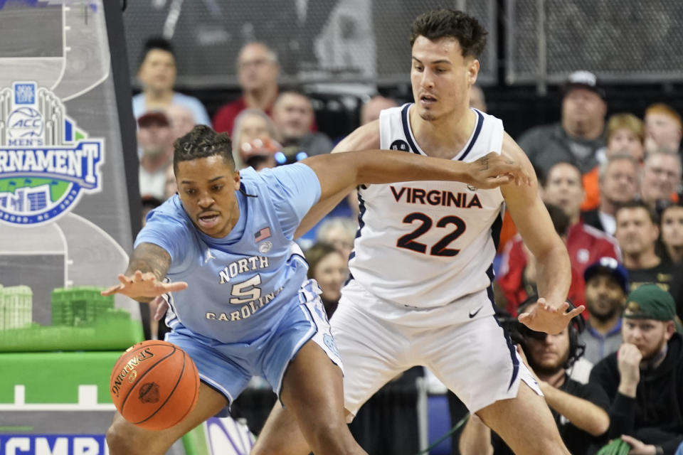 North Carolina forward Armando Bacot (5) tries to hang on to the ball as Virginia center Francisco Caffaro (22) defends during the first half of an NCAA college basketball game at the Atlantic Coast Conference men's tournament in Greensboro, N.C., Thursday, March 9, 2023. (AP Photo/Chuck Burton)