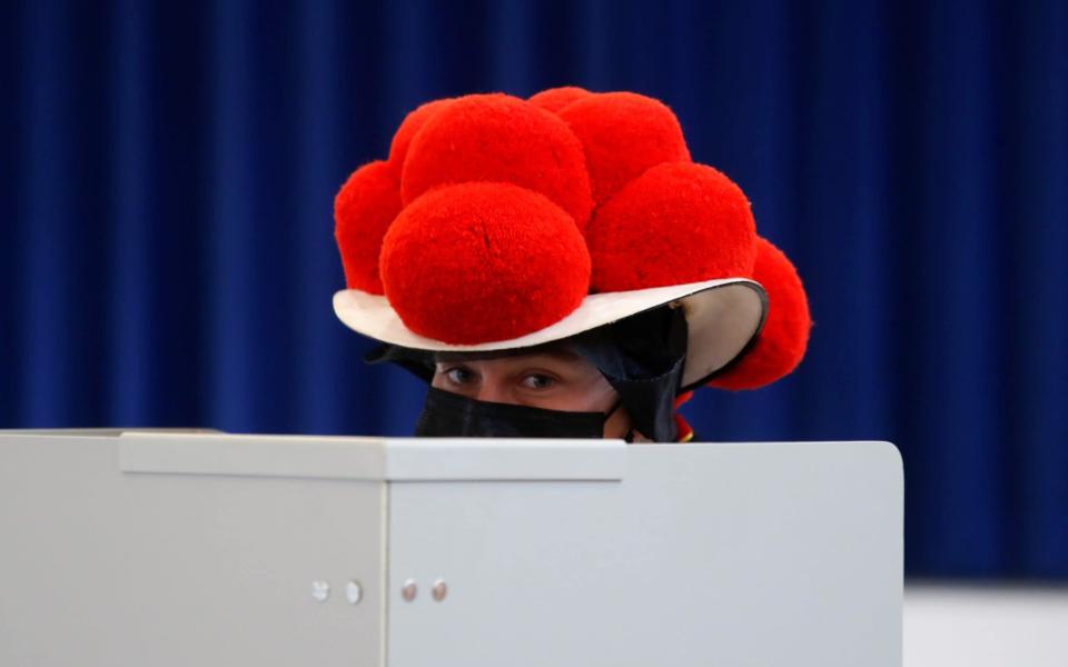 A woman wearing traditional Black Forest costume votes in Gutach, in the Black Forest, Germany, September 26, 2021. REUTERS/Arnd Wiegmann - ARND WIEGMANN /REUTERS 