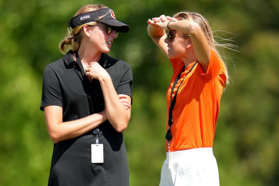 Cincinnati Bengals senior manager of digital strategy Caroline Blackburn, left, and director of strategy & engagement Elizabeth Blackburn, right, talk during NFL training camp practice, Monday, July 31, 2023, in Cincinnati.