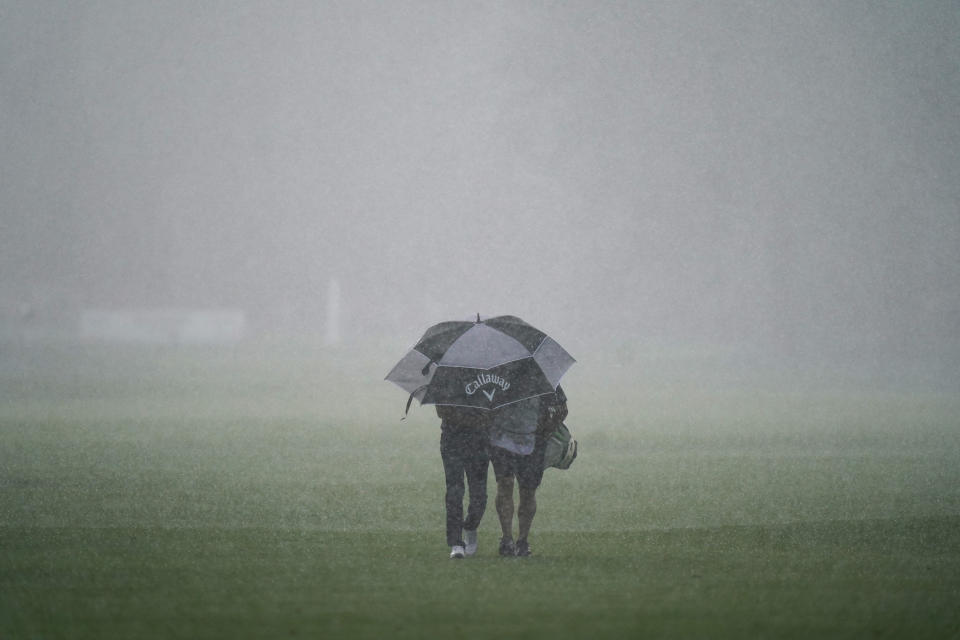 Sebastian Cappelan and his caddie walk to shelter on the fourth fairway during a rainstorm in the first round of the Rocket Mortgage Classic golf tournament, Thursday, July 1, 2021, at the Detroit Golf Club in Detroit. (AP Photo/Carlos Osorio)