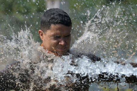 A member of a rescue team is sprayed with water to remove mud, upon returning from a rescue mission, after a tailings dam owned by Brazilian mining company Vale SA collapsed, in Brumadinho, Brazil January 28, 2019. REUTERS/Washington Alves