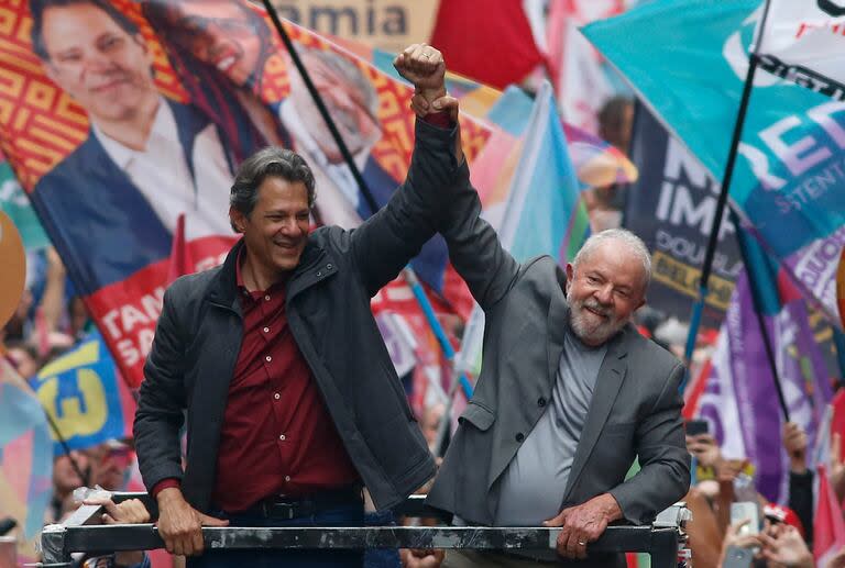 El presidente de Brasil Luiz Inácio Lula da Silva (R), y el ministro, Fernando Haddad, saludan a sus partidarios durante un mitin de campaña en Sao Paulo, Brasil, el 1 de octubre de 2022