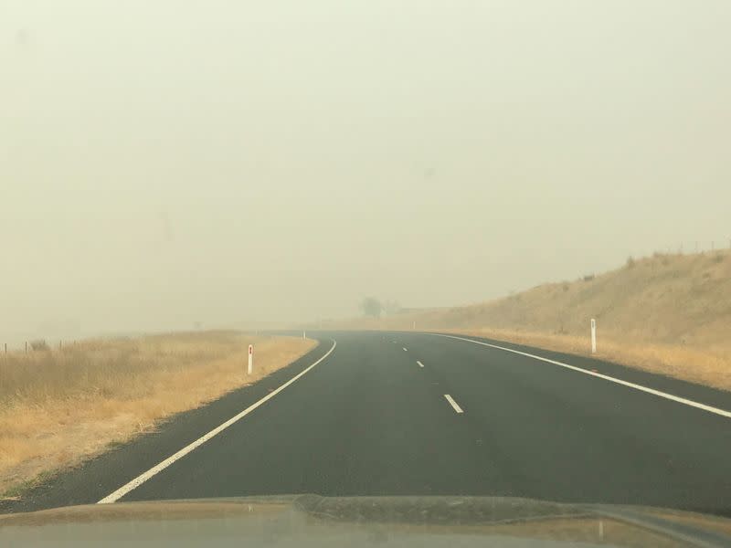 A view of a road partially shrouded in haze is seen from a vehicle in Jindabyne, a township affected by the Dunns Road bushfire, in New South Wales, Australia
