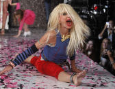 Designer Betsey Johnson goes into a split after doing a cartwheel on the runway after the Betsey Johnson Spring 2013 collection show during Fashion Week, Tuesday, Sept. 11, 2012, in New York. (AP Photo/Jason DeCrow)