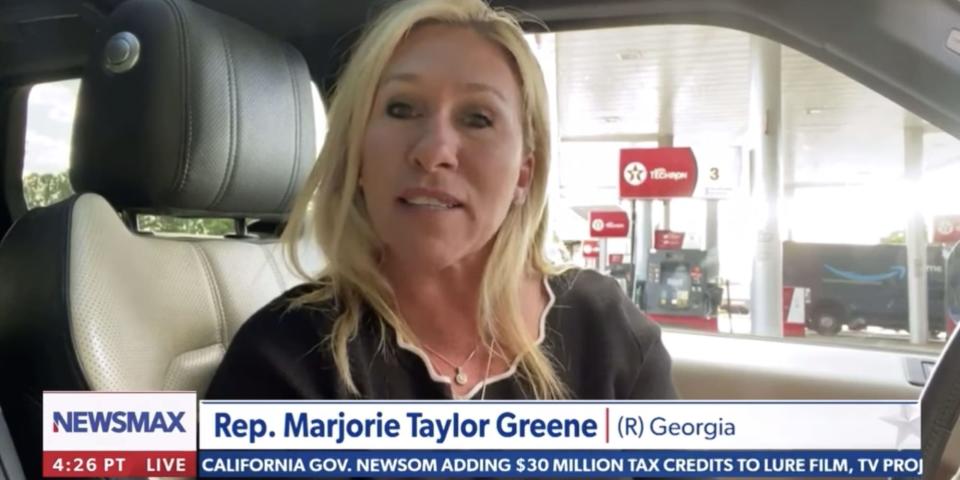 A screenshot of Rep. Marjorie Taylor Green sitting in her car during an interview with Newsmax.