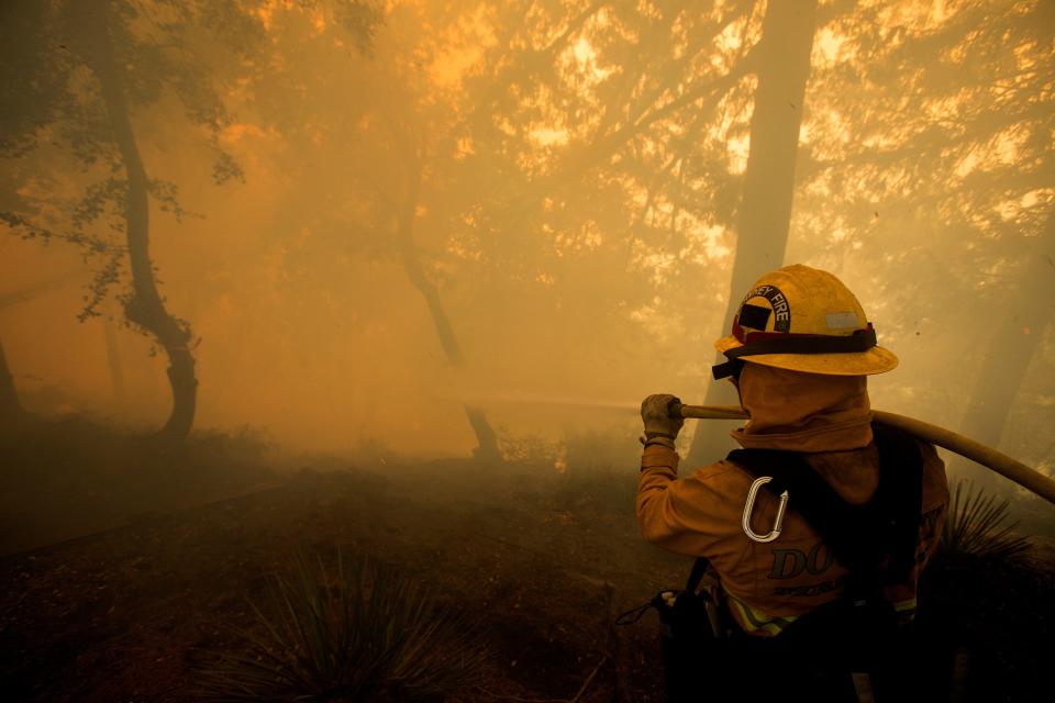 A firefighter battles a wildfire near a structure while defending the Mount Wilson observatory  (REUTERS)