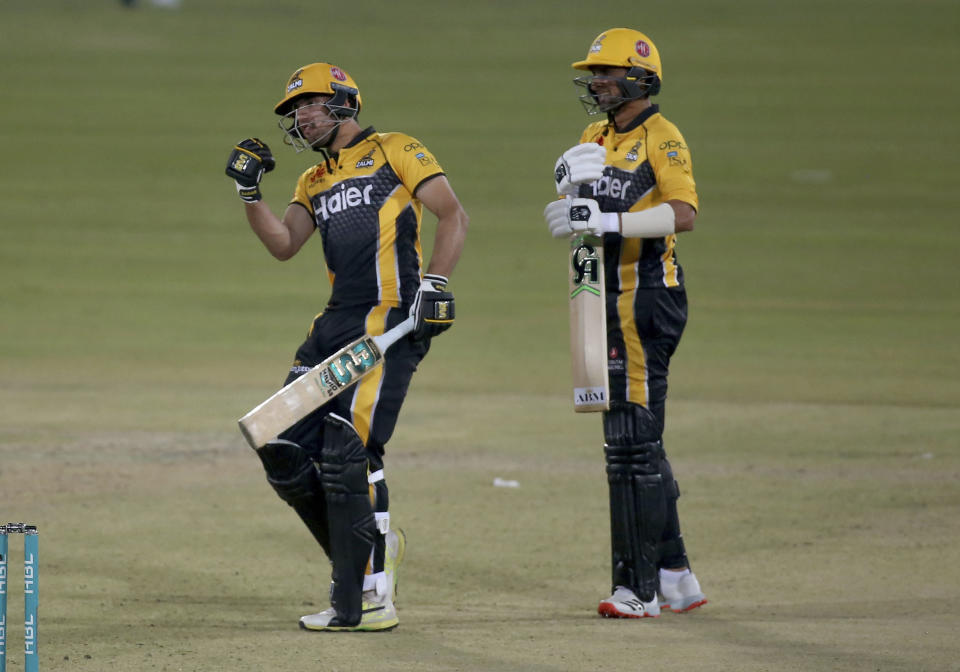 Peshawar Zalmi Haider Ali, left, celebrates after playing winning score while teammate Shoaib Malik watches during a Pakistan Super League T20 cricket match between Multan Sultans and Peshawar Zalmi at the National Stadium, in Karachi, Pakistan, Tuesday, Feb. 23, 2021. (AP Photo/Fareed Khan)