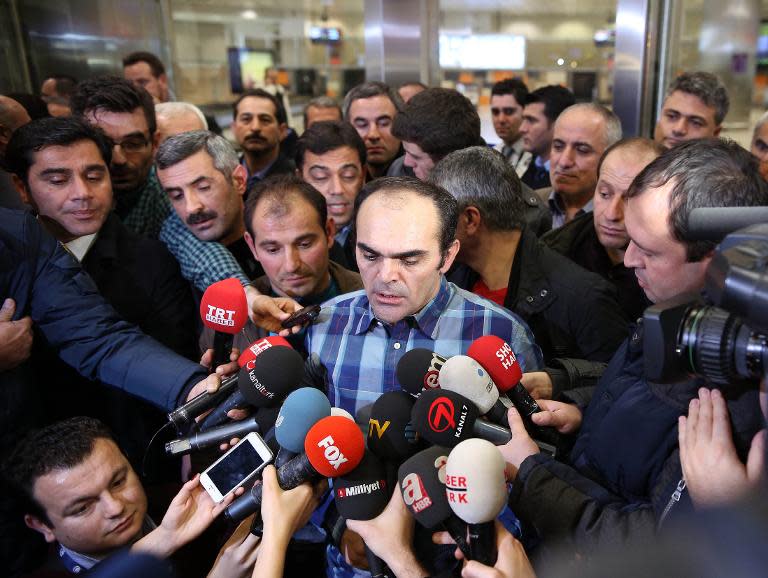 Turkish journalist and photographer Bunyamin Aygun (C) speaks to media after his arrival at the Ataturk airport in Istanbul on January 6, 2014