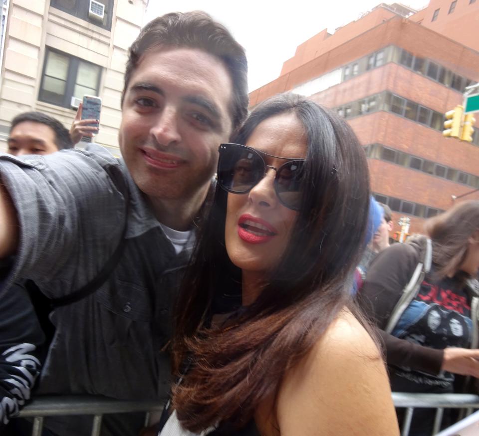 Salma Hayek smiles proudly for the camera with a male fan