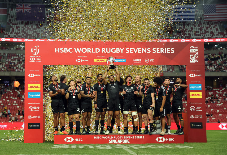 New Zealand players celebrate as they lift the HSBC Singapore Rugby Sevens trophy. 