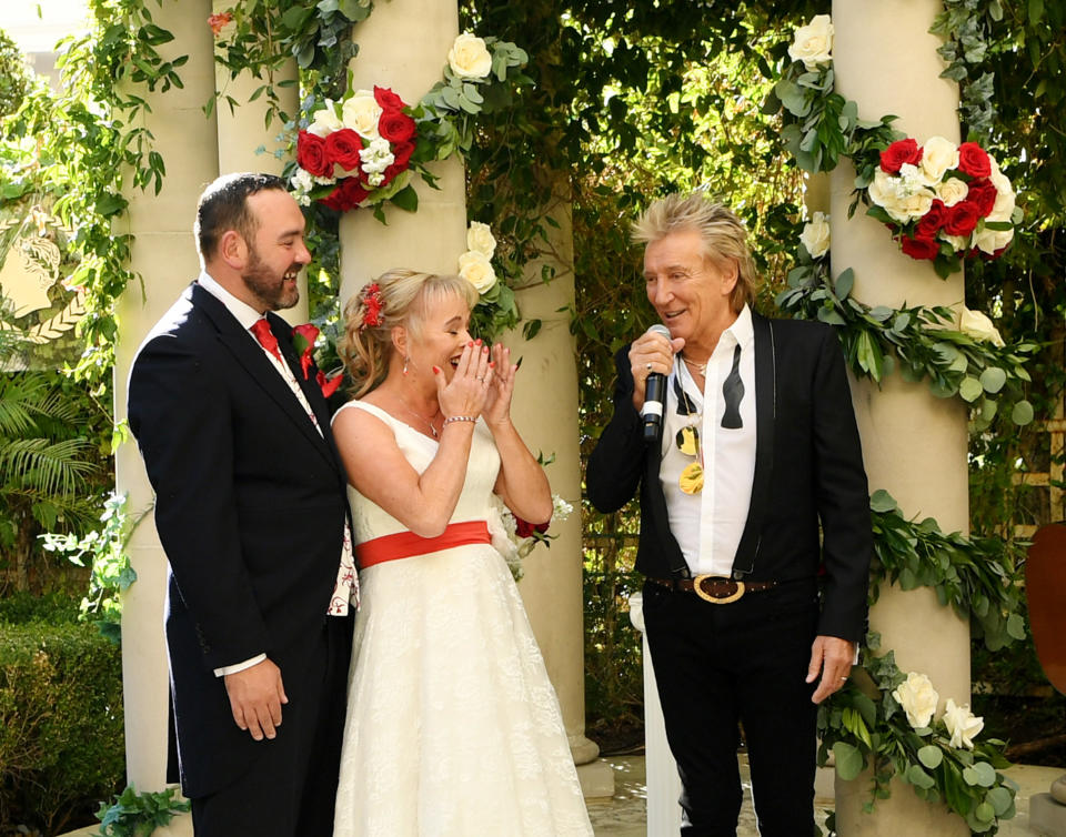 LAS VEGAS, NEVADA - OCTOBER 02: (EXCLUSIVE COVERAGE)  Sir Rod Stewart (R) sings during the wedding of Sharon Cook (C) and Andrew Aitchison (L) from Liverpool, England. The wedding was nearly cancelled due to the Thomas Cook Bankruptcy. Caesars Palace and Delta Air Lines flew the couple and their guests to Las Vegas as originally planned. The Wedding took place at Caesars Palace on October 02, 2019 in Las Vegas, Nevada. (Photo by Denise Truscello/WireImage)