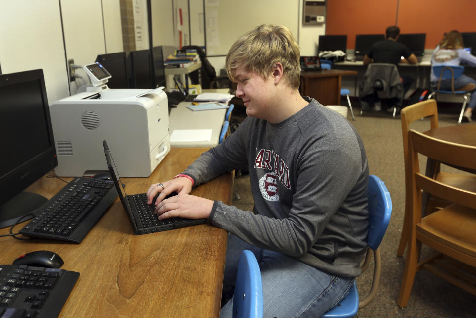 Braxton Moral, 16, sits in the computer room of Ulysses High School in Ulysses, Kan., on Wednesday, Dec. 12, 2018. The senior uses the computer room to work on his Harvard studies for approximately three hours each school day. He is projected to graduate from Harvard and then graduate from Ulysses later in May 2019. (Sandra J. Milburn/The Hutchinson News via AP)