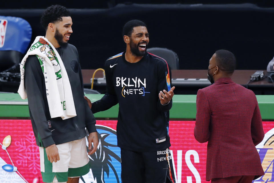 Brooklyn Nets' Kyrie Irving, center, talks with Boston Celtics' Jayson Tatum, left, and Kemba Walker, right, following an NBA basketball game Friday, Dec. 25, 2020, in Boston. (AP Photo/Michael Dwyer)