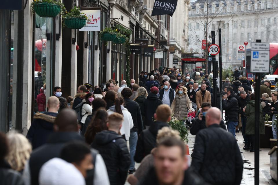 Shoppers, some wearing a facemask to combat the spread of Covid-19, walk along Regent Street in London on December 28, 2021. (Photo by Hollie Adams / AFP) (Photo by HOLLIE ADAMS/AFP via Getty Images)