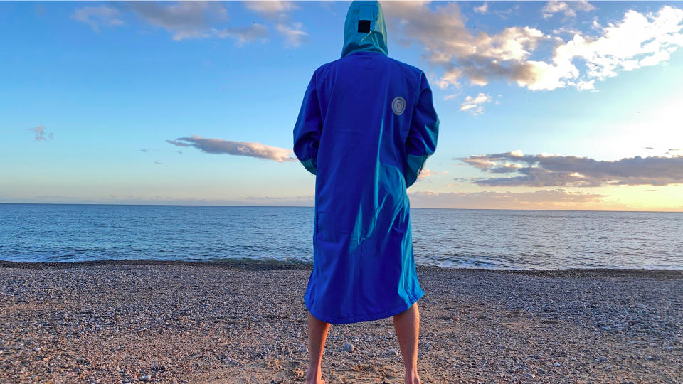 Man on beach wearing White Water Softshell Robe (showing the back)