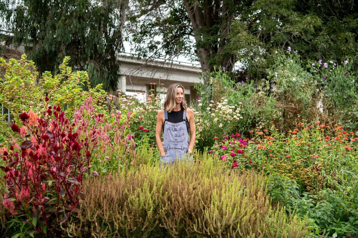 A woman stands in a flower garden