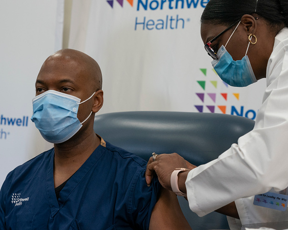 Doctor of Nursing Practice Michelle Chester administers COVID-19 vaccine to doctor Yves Duroseau of Lenox Hill Hospital at Northwell Health. 