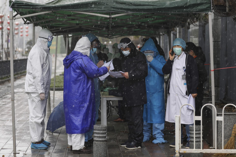 Government workers wait for patients to arrive at a tumor hospital newly designated to treat COVID-19 patients in Wuhan in central China's Hubei Province, Saturday, Feb. 15, 2020. The virus is thought to have infected more than 67,000 people globally and has killed at least 1,526 people, the vast majority in China, as the Chinese government announced new anti-disease measures while businesses reopen following sweeping controls that have idled much of the economy. (Chinatopix via AP)