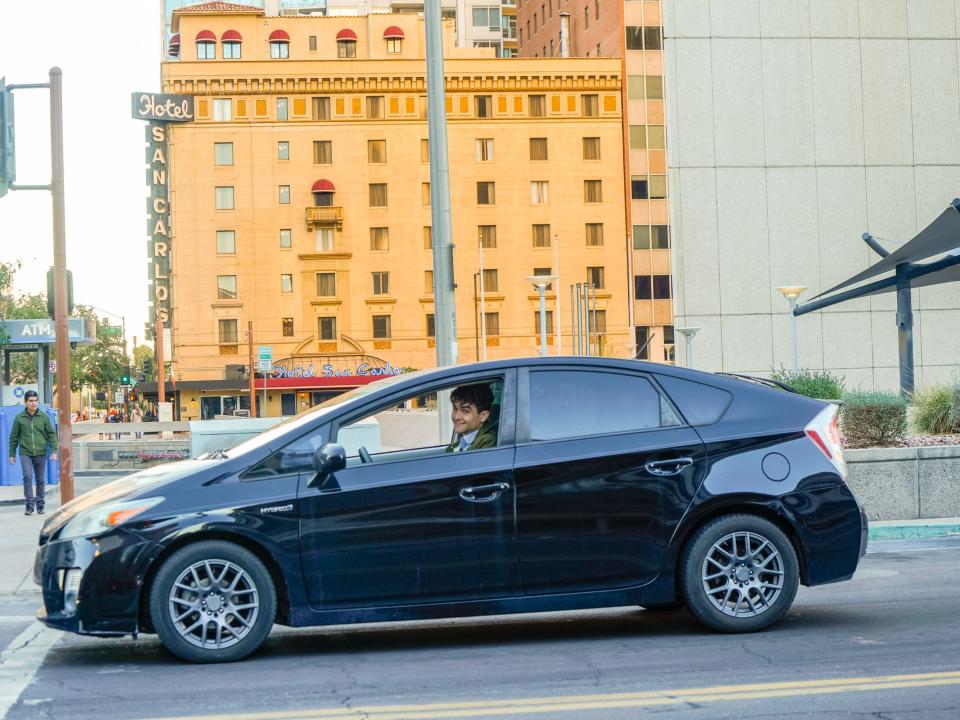 A person drives a Prius in downtown Phoenix
