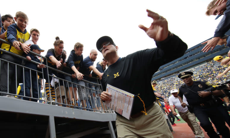 Jim Harbaugh walking off the field after a football game.