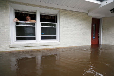 Obrad Gavrilovic peers out the window of his flooded home while considering whether to leave with his wife and pets, as waters rise in Bolivia, North Carolina, U.S., September 15, 2018. REUTERS/Jonathan Drake TPX IMAGES OF THE DAY