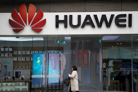 FILE PHOTO: A woman walks by a Huawei logo at a shopping mall in Shanghai, China December 6, 2018. REUTERS/Aly Song/File Photo