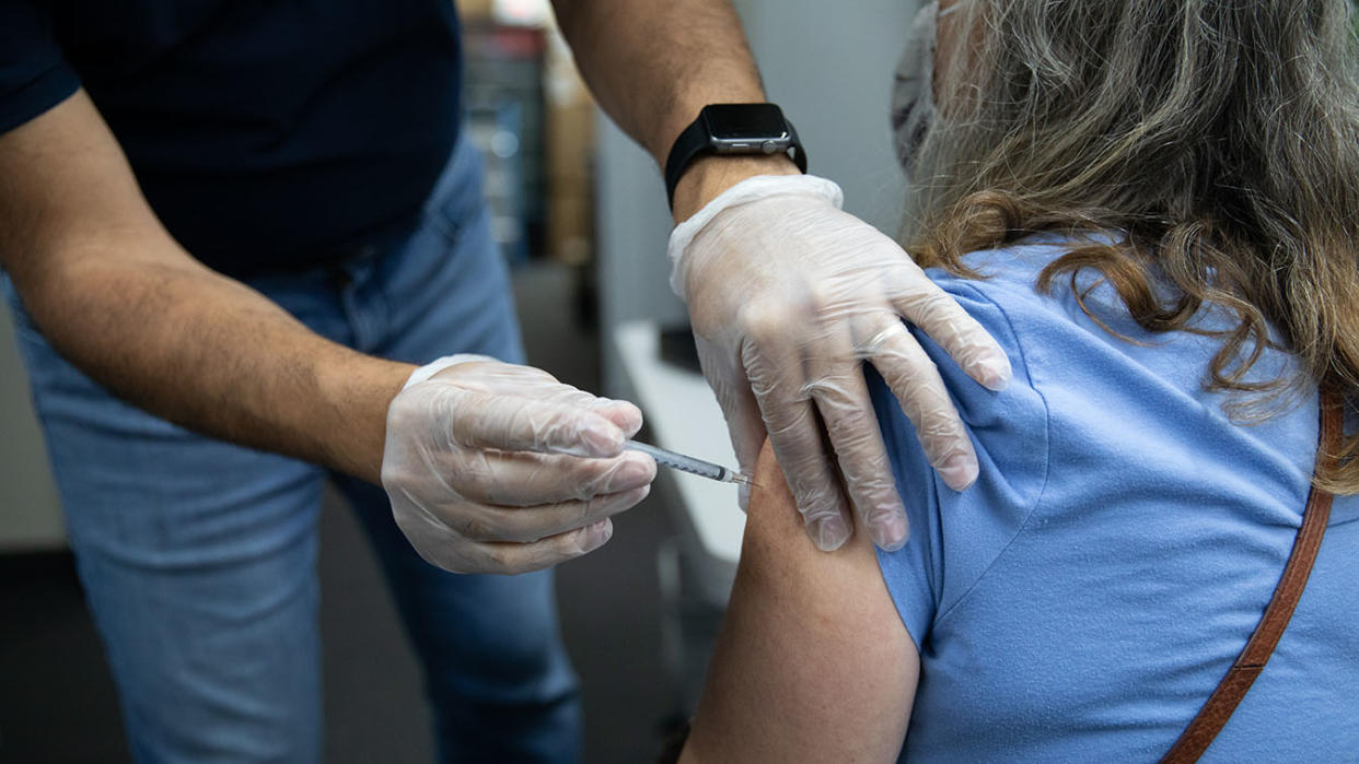 A pharmacist administers a third dose of the Pfizer-BioNTech Covid-19 vaccine to a customer at a pharmacy in Livonia, Michigan on  Aug. 17, 2021. (Emily Elconin/Bloomberg via Getty Images)