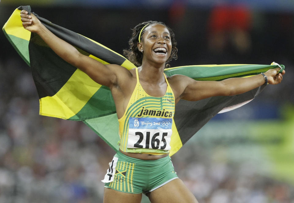 FILE - Shelly-Ann Fraser celebrates with the Jamaican flag after winning the gold medal in the women's 100-meter final during the athletics competitions in the National Stadium at the Beijing 2008 Olympics in Beijing, Sunday, Aug. 17, 2008. Fraser-Pryce said the Paris Games will be her fifth and final Olympics.(AP Photo/Anja Niedringhaus, File)