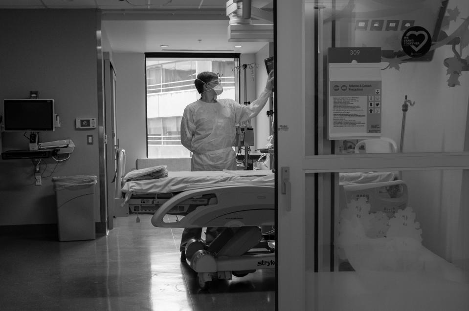 Dr. Christopher Monson wears PPE as he resets a monitor to prepare for a COVID patient coming to the PICU at the University of Iowa Stead Children's Hospital.