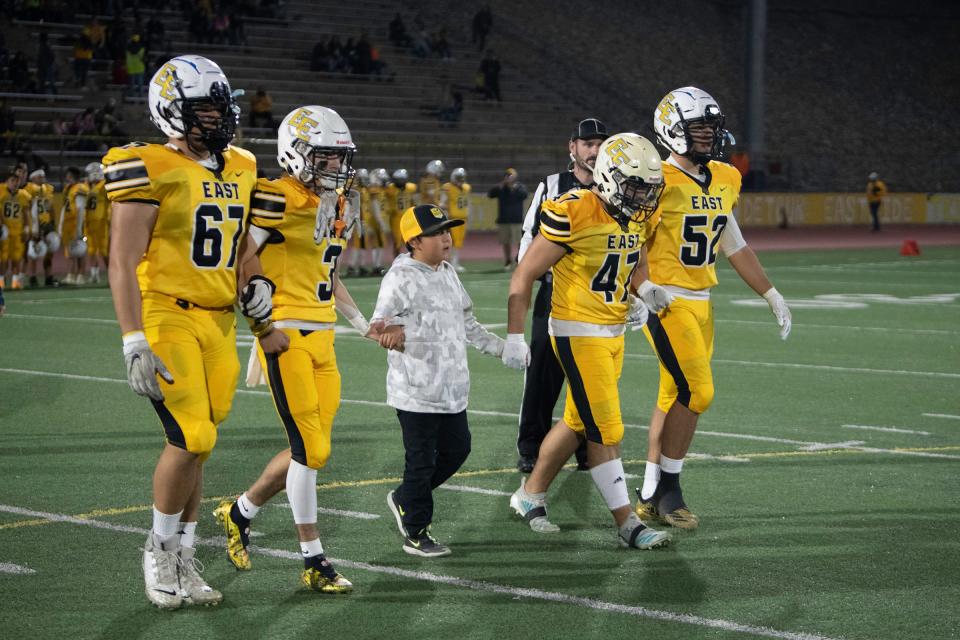 The Pueblo East High School football captains head to midfield for the coin toss to start the 2021 Cannon Game against Pueblo South at Dutch Clark Stadium on Friday, October 22, 2021.